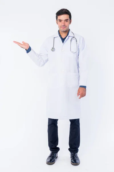 何かを示す若いペルシャの男性医師のフルボディショット — ストック写真