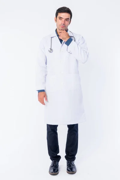 Full body shot of young Persian man doctor thinking — Stock Photo, Image