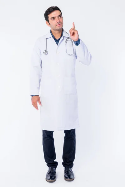 Full body shot of young Persian man doctor thinking and pointing up — Stock Photo, Image