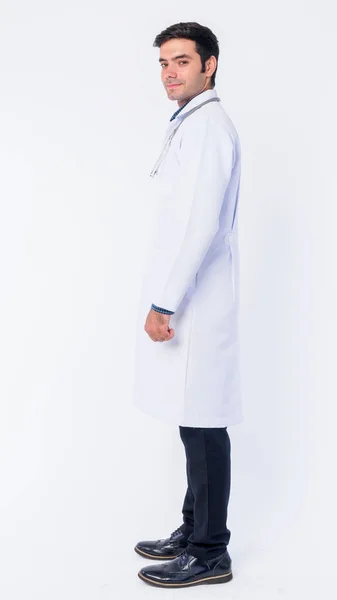 Full body shot profile view of young Persian man doctor looking at camera — Stock Photo, Image