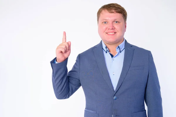 Portrait of happy overweight businessman in suit pointing up — Stock Photo, Image