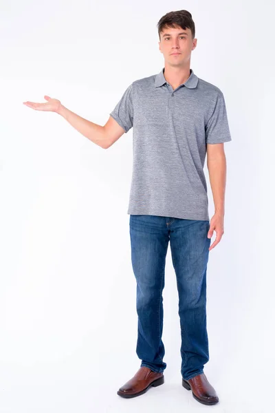 Full body shot of young handsome man showing something — Stock Photo, Image