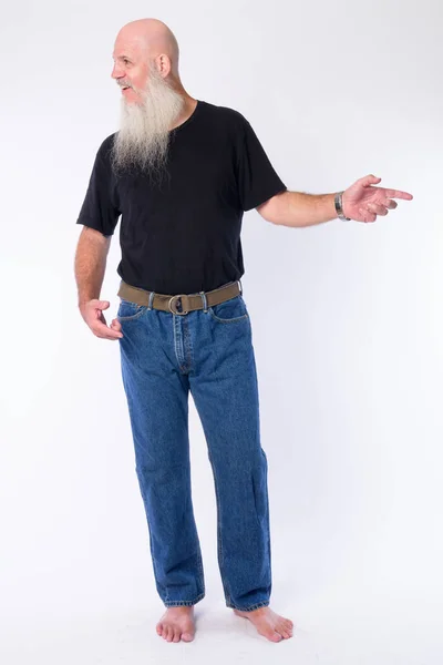 Mutlu olgun kel sakallı adam parmak işaret ve uzağa bakarak tam vücut atış — Stok fotoğraf
