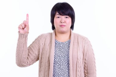 Kısa saçlı, kilolu, beyaz arka planda izole bir Asyalı kadının stüdyo fotoğrafı.