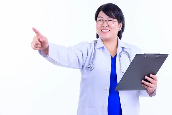 Boldog túlsúlyos ázsiai nő orvos mutatva ujját, miközben a vágólap — Stock Fotó