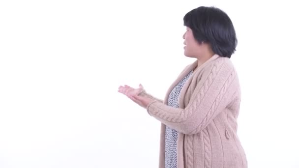Ευτυχισμένη υπέρβαρη Ασιάτισσα γυναίκα μιλάει ενώ δείχνει την πλάτη της για το χειμώνα — Αρχείο Βίντεο