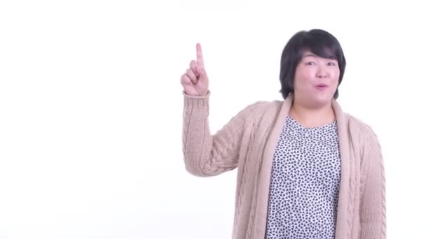 Sorprendido sobrepeso mujer asiática apuntando hacia arriba listo para el invierno — Vídeo de stock
