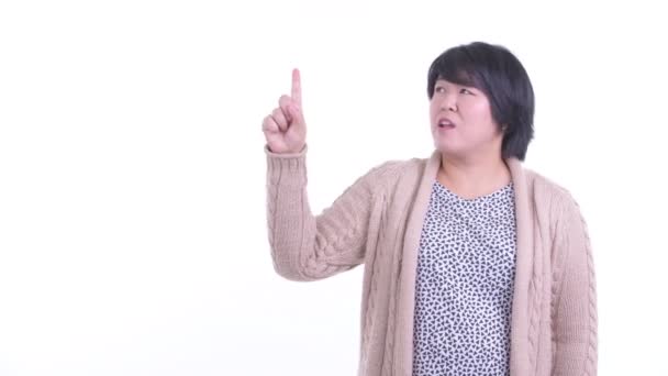 Estresado sobrepeso mujer asiática señalando hacia arriba y recibiendo malas noticias para el invierno — Vídeos de Stock