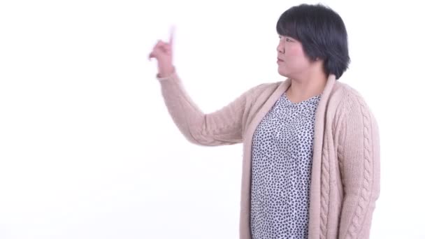 Happy overweight Asian woman touching something and ready for winter — Stock Video