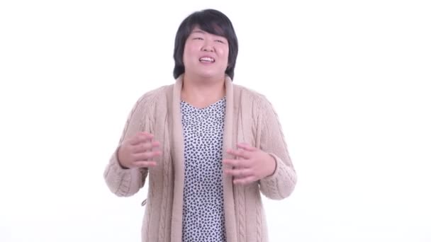 Щаслива жінка з надмірною вагою, азіатка розмовляє з камерою і готова до зими — стокове відео