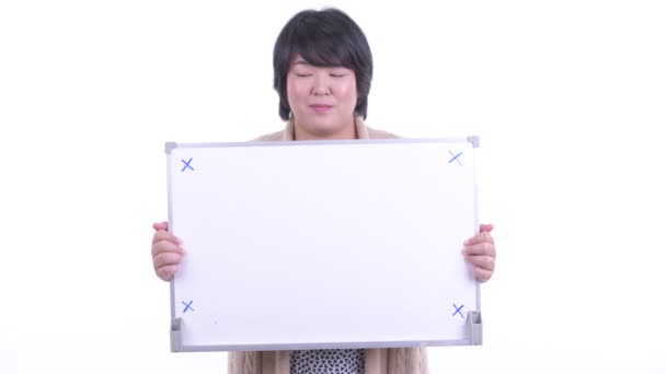Feliz mujer asiática con sobrepeso sosteniendo pizarra blanca y recibiendo buenas noticias para el invierno — Vídeo de stock