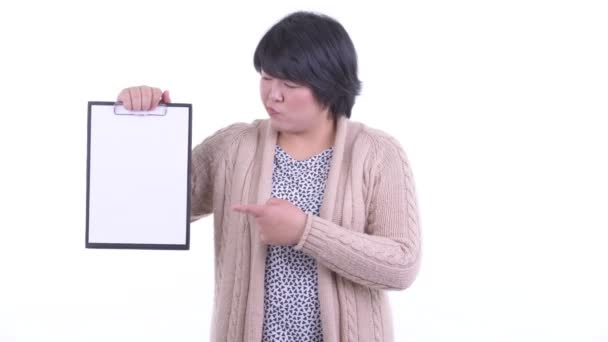 Stresszes túlsúlyos ázsiai nő mutatja írótábla és így hüvelykujját le készen áll a télre — Stock videók