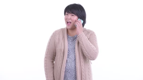 Glad överviktig asiatisk kvinna pratar i telefon redo för vintern — Stockvideo