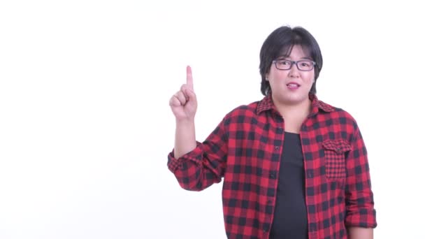 Feliz sobrepeso asiático hipster mujer hablando mientras apuntando hacia arriba — Vídeo de stock
