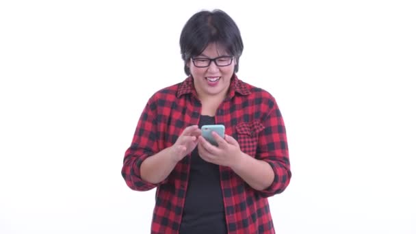 Heureuse femme hipster asiatique en surpoids utilisant le téléphone et obtenir de bonnes nouvelles — Video