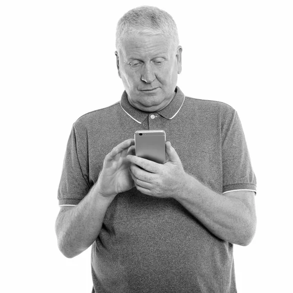 Studio shot of mature man using mobile phone — Stock Photo, Image