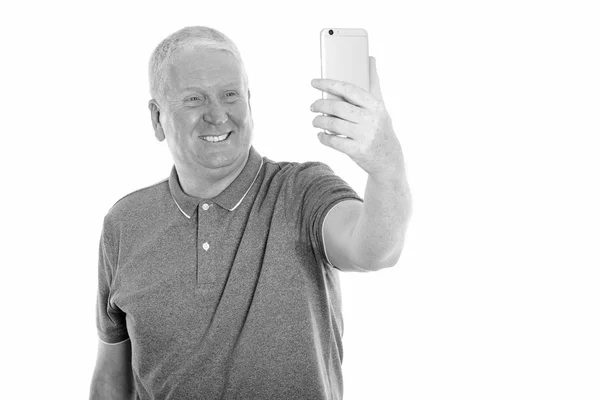 Stúdió lövés boldog érett férfi mosolyogva, miközben figyelembe selfie kép-val mozgatható telefon — Stock Fotó