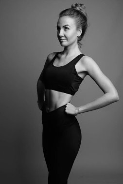 Gri arka planda jimnastiğe hazır güzel bir kadının stüdyo çekimi.