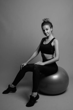 Gri arka planda jimnastiğe hazır güzel bir kadının stüdyo çekimi.