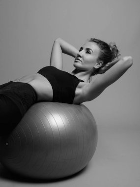 Gri arka planda jimnastiğe hazır güzel bir kadının stüdyo çekimi.