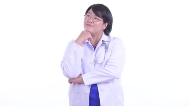 Happy overweight Asian woman doctor thinking and looking up — Stock Video