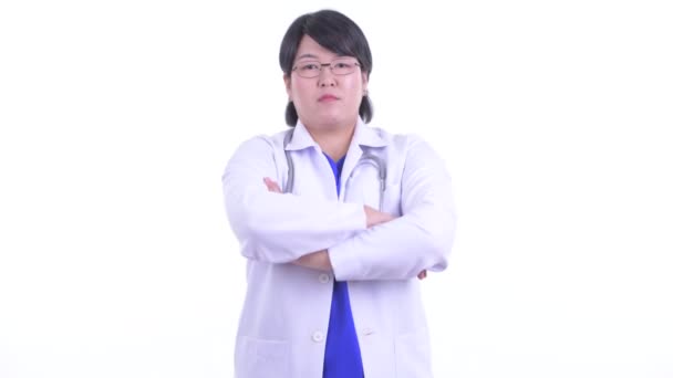 Счастливая толстая азиатка-доктор улыбается со скрещенными руками — стоковое видео