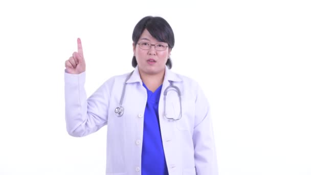 Heureux en surpoids asiatique femme médecin pointant vers le haut — Video