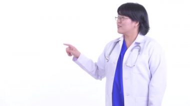 Mutlu kilolu Asyalı kadın doktor bir şey dokunmadan ve başparmak veren