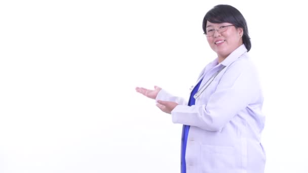 Χαρούμενος υπέρβαρων Ασιάτης/ισσα γυναίκα γιατρός μιλάει ενώ δείχνει στο πίσω μέρος — Αρχείο Βίντεο