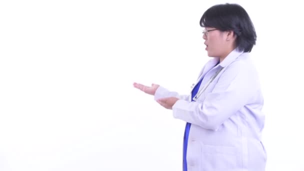 Gestrest overgewicht Aziatische vrouw arts praten terwijl tonen aan de achterkant — Stockvideo