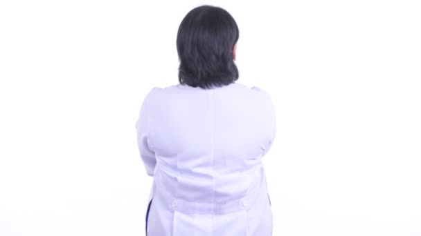 Rear view of overweight Asian woman doctor thinking and looking around — Stock Video