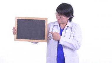 Stresli kilolu Asyalı kadın doktor kara tahta tutan ve başparmak aşağı vererek