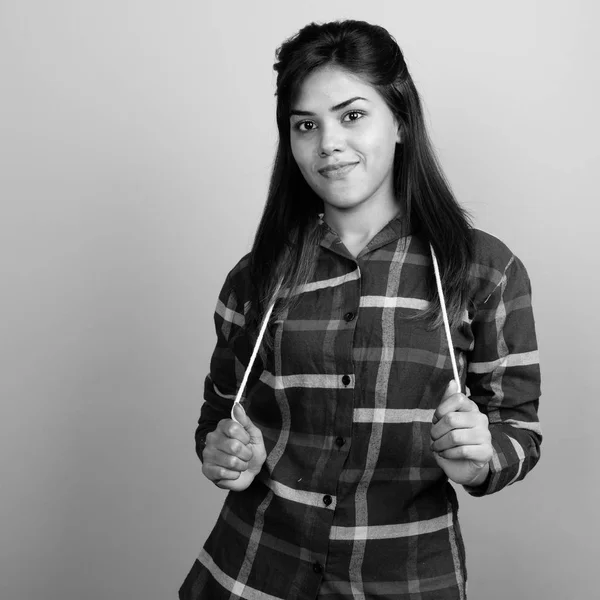회색 배경에 대한 체크 셔츠를 입고 젊은 아름다운 인도 여자 — 스톡 사진