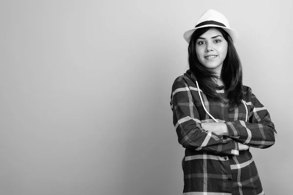 Mladá krásná indická turistická žena, oblečená v košili a klobouku na šedé pozadí — Stock fotografie