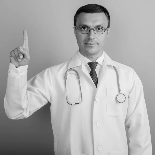 Mand læge iført briller på grå baggrund - Stock-foto