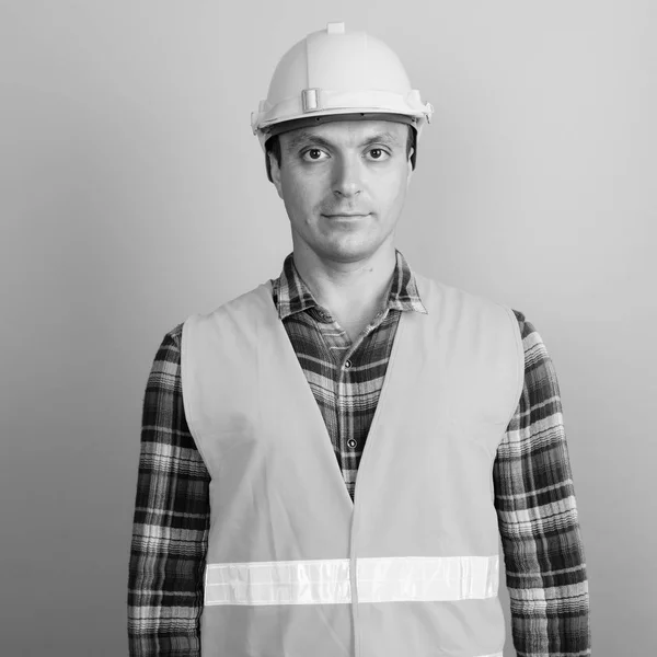 Hombre trabajador de la construcción contra fondo gris tiro en blanco y negro —  Fotos de Stock