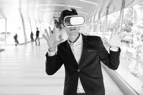 Joven hombre de negocios guapo usando gafas VR al aire libre — Foto de Stock