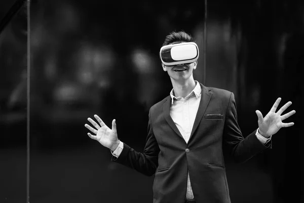 Empresário usando óculos VR para realidade virtual na cidade — Fotografia de Stock