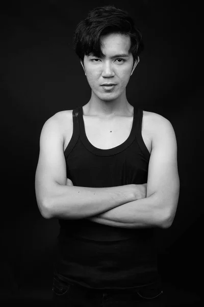Молодой красивый азиат на черном фоне — стоковое фото
