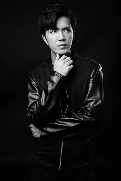 Ung Vacker asiatisk man tänker mot svart bakgrund — Stockfoto