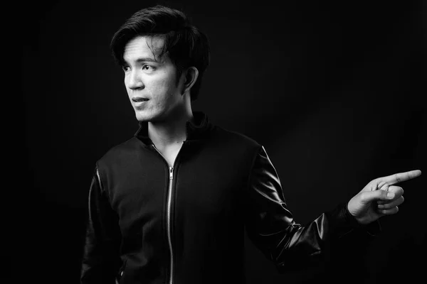 Jonge knappe Aziatische man tegen zwarte achtergrond — Stockfoto