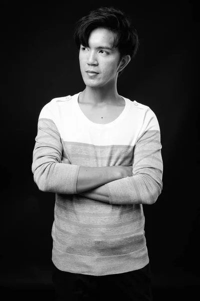 Fiatal csinos ázsiai ember gondolkodás fekete háttér — Stock Fotó