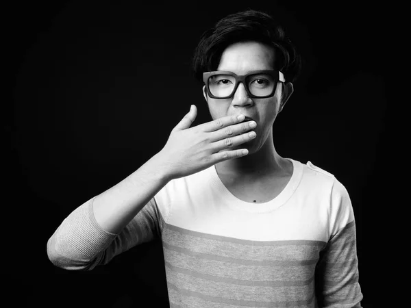 Young handsome Asian man looking shocked against black background — Stock Photo, Image