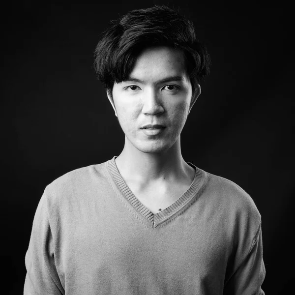 Genç yakışıklı Asya adam siyah arka plan — Stok fotoğraf