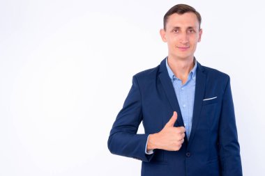 Takım elbiseli işadamının stüdyo fotoğrafı başparmak larını dağıtıyor