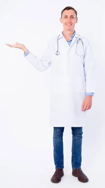 Повний знімок тіла щасливого лікаря, який щось показує — стокове фото