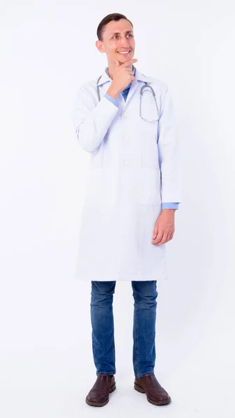 Full body shot of happy man doctor thinking and looking up — Stock Photo, Image