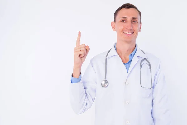 Студійний знімок щасливого лікаря, який вказує пальцем вгору — стокове фото