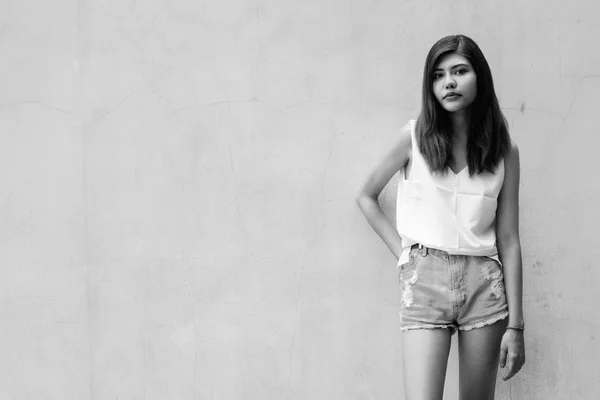 Hermosa chica adolescente gris fondo de la pared al aire libre tiro en blanco y negro —  Fotos de Stock