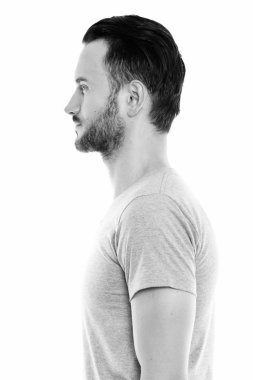 Black and white studio portrait of handsome young man with beard
